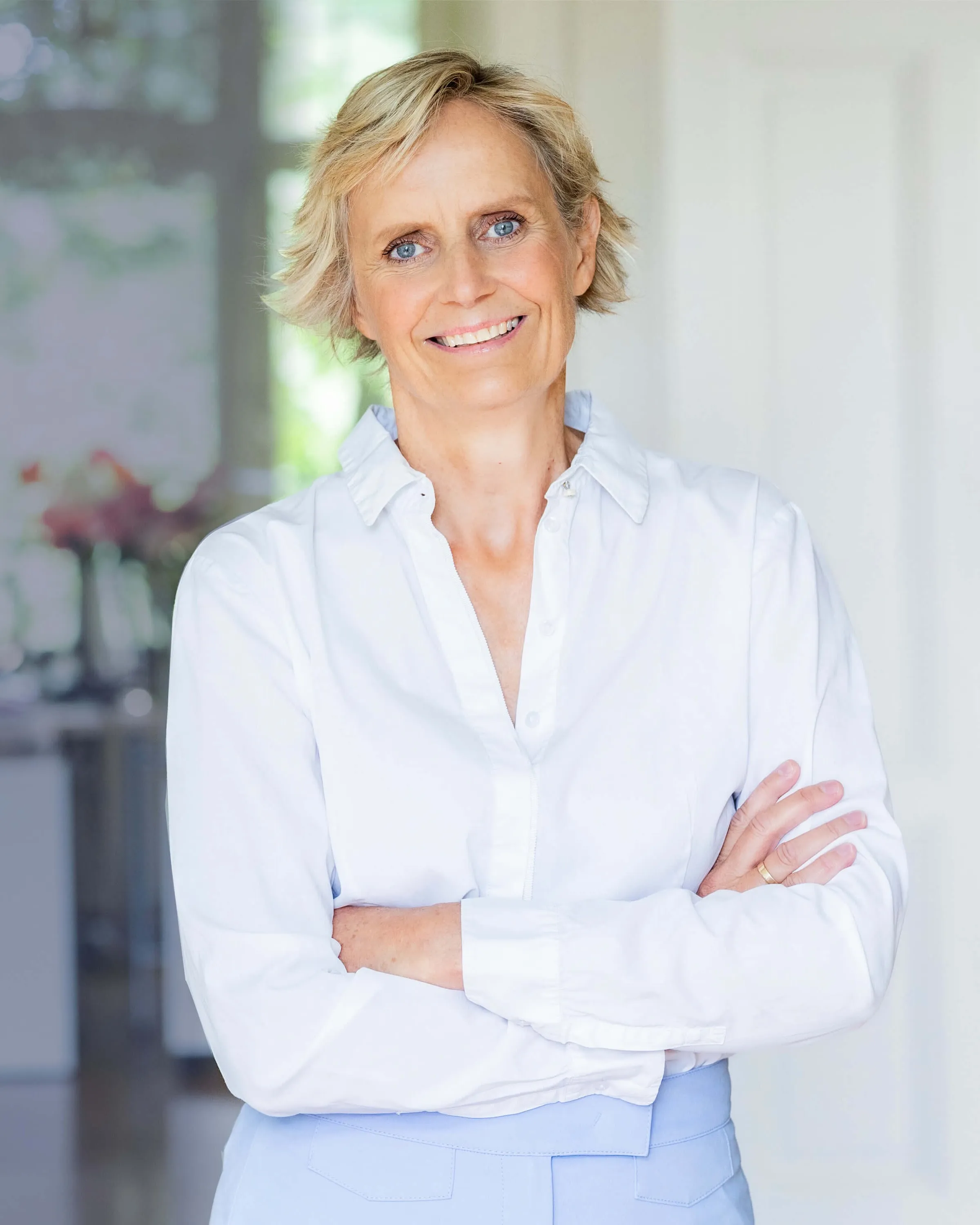 Christina Janssen mit verschränkten Armen in einem hellen Raum